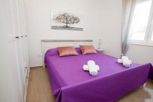 a purple bed with two hello kitty towels on it at Luxury apartment Eva in Zadar