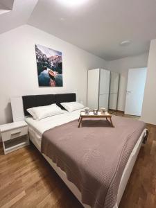 Un dormitorio con una cama grande y una mesa. en Apartman Anton, en Zagreb