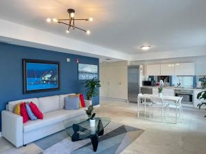 ein Wohnzimmer mit einem weißen Sofa und einem Tisch in der Unterkunft Beachfront Apt in Carlyle Hotel on Ocean Drive in Miami Beach