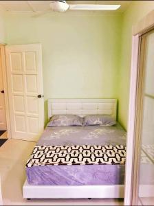 ein Schlafzimmer mit einem Bett in einem Zimmer mit einer Tür in der Unterkunft Homestay Tok Wan Puchong Utama in Puchong