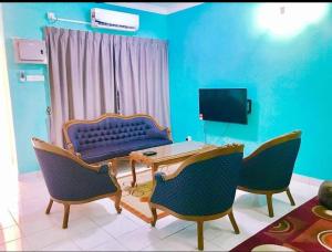 - un salon avec un canapé, une table et des chaises dans l'établissement Homestay Tok Wan Puchong Utama, à Puchong