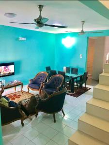 ein Wohnzimmer mit blauen Wänden und Stühlen sowie einem Tisch in der Unterkunft Homestay Tok Wan Puchong Utama in Puchong