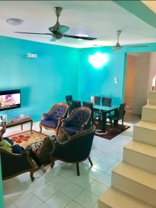 a living room with blue walls and chairs and a table at Homestay Tok Wan Puchong Utama in Puchong