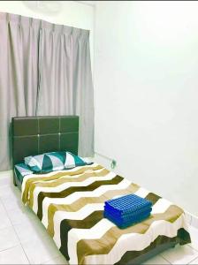 Schlafzimmer mit einem Bett mit einem grünen Kopfteil und Kissen in der Unterkunft Homestay Tok Wan Puchong Utama in Puchong