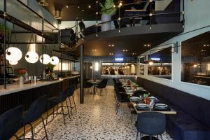 a restaurant with tables and chairs and a bar at The Port Square Hotel in Piraeus