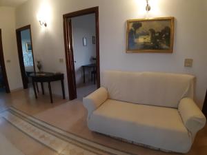 sala de estar con sofá blanco y mesa en Villa Guido, en Regalbuto