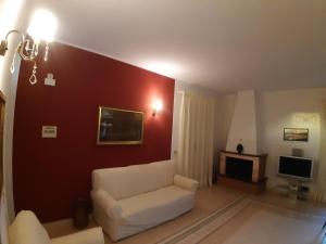 a living room with a white couch and a red wall at Villa Guido in Regalbuto