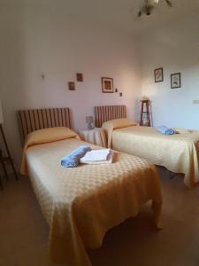 1 dormitorio con 2 camas con sábanas de color naranja en Villa Guido, en Regalbuto