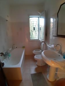 a bathroom with two toilets and a tub and a sink at Villa Guido in Regalbuto