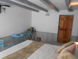 Schlafzimmer mit einem Bett, einem Tisch und Stühlen in der Unterkunft Les Landes in Saint-Pardoux-Corbier