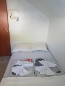 a bed with two pairs of shoes on it at Apartman Salus in Tuzla