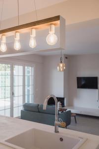 een keuken met een wastafel en een woonkamer met een bank bij Locanda Villas in Lefkada