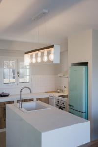 een witte keuken met een wastafel en een koelkast bij Locanda Villas in Lefkada