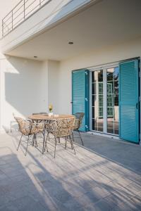 een patio met een tafel en stoelen voor een huis bij Locanda Villas in Lefkada