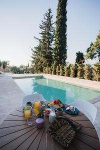 een tafel met eten en drinken naast een zwembad bij Locanda Villas in Lefkada