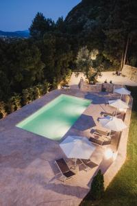 een uitzicht over een zwembad met stoelen en parasols bij Locanda Villas in Lefkada