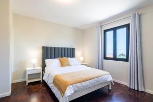 Un dormitorio con una cama grande y una ventana en Villa Pearl, en Santana