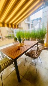 Une table et des chaises en bois sont disponibles sur la terrasse. dans l'établissement Burgas apartment, à Bourgas