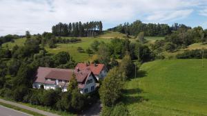 een luchtzicht op een huis in een groen veld bij Ferienwohnung Hobbyhof Deggenhausertal in Deggenhausertal