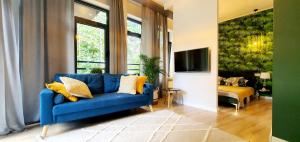 a living room with a blue couch and a tv at Apartament nad Zalewem in Serock