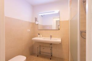 łazienka z umywalką, toaletą i lustrem w obiekcie San Hermenegildo City Walls by Valcambre w Sewilli +13 zdjęć