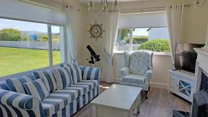 a living room with a couch and two chairs and a tv at Southland Holiday Home in Milltown Malbay