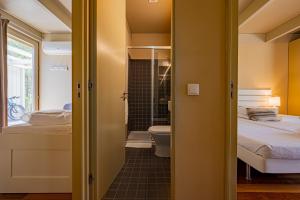 a small bathroom with a bed and a toilet at Pestana Troia Eco-Resort & Residences in Troia