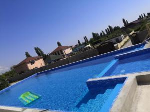 a large swimming pool with blue water at Ararat House in Tsandrypsh