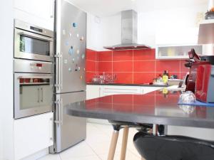Il comprend une cuisine équipée d'un réfrigérateur en acier inoxydable et d'une table. dans l'établissement Maison Saint-Georges-d'Oléron, 4 pièces, 6 personnes - FR-1-246A-133, à Saint-Georges-dʼOléron