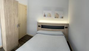 a small bedroom with two beds and a door at Pensión A Carballeira in Villalba