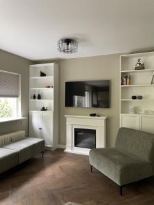 - un salon avec un canapé et une cheminée dans l'établissement Comfortabel tot rust komen in het Veluwse bos, à Otterlo
