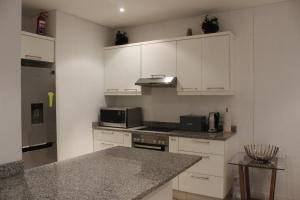 a kitchen with white cabinets and a counter top at Beacon Rock - 6 sleeper Luxurious Apartment in Durban