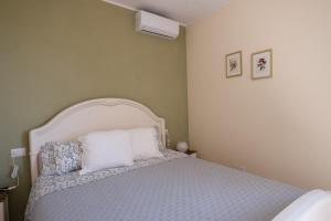 um quarto com uma cama branca e 2 almofadas em Agriturismo I Grappoli em Alberese