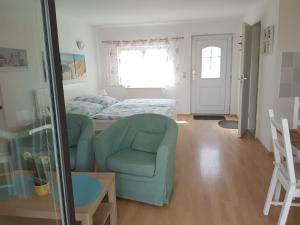 ein Wohnzimmer mit einem Bett und einem Stuhl in der Unterkunft Bungalow in Stralsund