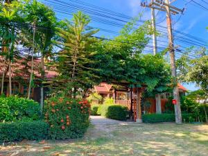 a house with trees and bushes in front of it at Seamthong Resort เสียมทองรีสอร์ท in Ban Siam