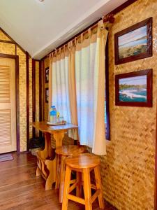 a room with a table and two stools at Seamthong Resort เสียมทองรีสอร์ท in Ban Siam