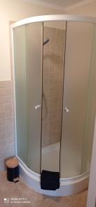 a shower with a glass door in a bathroom at Sardyna Bałtycka in Bobolin