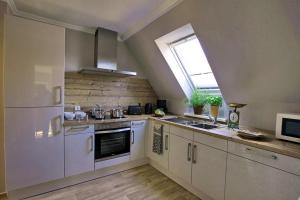 a kitchen with white cabinets and a window at Ferienwohnung an Schleusenanlage NOK in Brunsbüttel