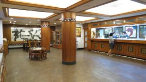 a woman standing in a large room with pillars at Rainbow Resort Hotel in Wenquan +52 photos