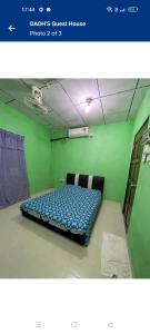 ein Schlafzimmer mit einem Bett in einem grünen Zimmer in der Unterkunft DAOH'S Rooms & Scooters in Tanjung Rhu