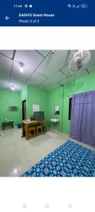 een kamer met groene muren en een houten tafel bij DAOH'S Rooms & Scooters in Tanjung Rhu 