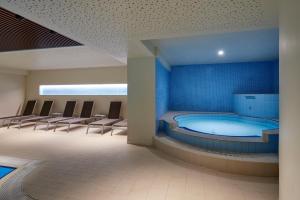 uma banheira de hidromassagem num quarto com cadeiras à volta em Grand Hotel Misurina em Misurina