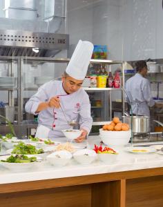a chef is preparing food in a kitchen at PHU THANG GRAND HOTEL in Ðức Hòa