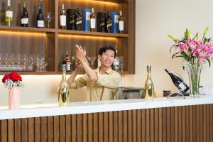 a man standing behind a bar with his hand up at PHU THANG GRAND HOTEL in Ðức Hòa