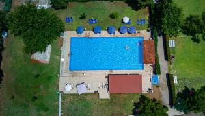 een uitzicht over een zwembad in een tuin bij Tsamadanis Hotel & Bungalows Friends Family in Karavómilos