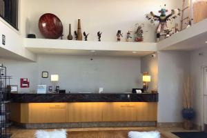 a lobby with a counter with vases on the wall at Baymont Inn & Suites by Wyndham Holbrook in Holbrook