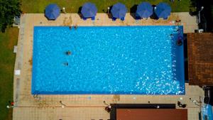 an overhead view of a large swimming pool with people in it at Tsamadanis Hotel & Bungalows Friends Family in Karavómilos