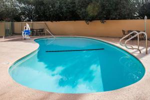 a large blue swimming pool in a yard at Super 8 by Wyndham Visalia in Visalia