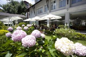 a garden with pink and white flowers and umbrellas at Muong Thanh Holiday Da Lat Hotel in Da Lat