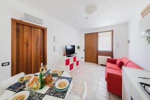 uma sala de estar com uma mesa e um sofá vermelho em Mandorli 1-18 by Wonderful Italy em Desenzano del Garda